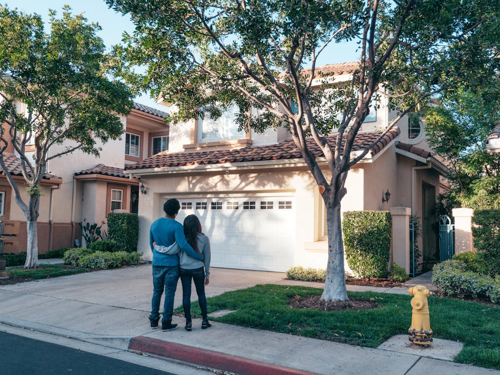 Naca mortgage. Couple hugging outside their newly purchased suburban home, showcasing togetherness and new beginnings.